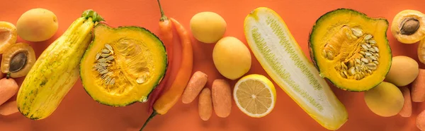 Blick von oben auf gelbes Obst und Gemüse auf orangefarbenem Hintergrund, Panoramaaufnahme — Stockfoto