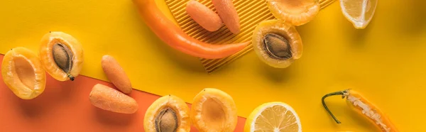 Top view of yellow fruits and vegetables on orange background, panoramic shot — Stock Photo