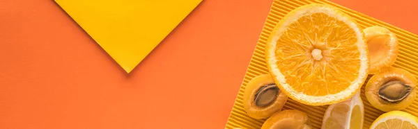 Top view of yellow fruits on orange background with copy space, panoramic shot — Stock Photo