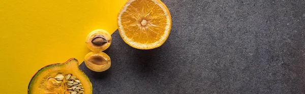 Top view of pumpkin, orange and apricot on yellow and grey background, panoramic shot — Stock Photo