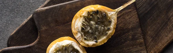 Top view of sweet granadilla on wooden cutting boards on grey background, panoramic shot — Stock Photo