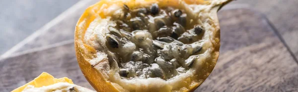 Close up view of sweet granadilla on wooden cutting boards on grey background, panoramic shot — Stock Photo