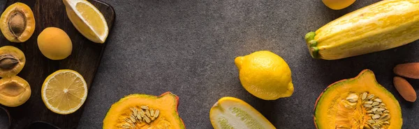 Vue du dessus des fruits et légumes jaunes sur planches à découper en bois sur fond gris, vue panoramique — Photo de stock