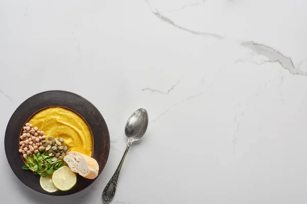 Vista dall'alto del purè di zucca autunnale zuppa sul tavolo di marmo con cucchiaio — Foto stock