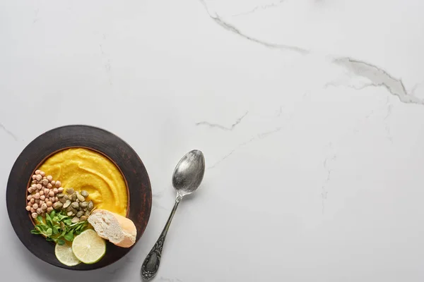 Top view of autumnal mashed pumpkin soup on marble table with spoon — Stock Photo