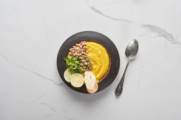 Vista dall'alto del purè di zucca autunnale zuppa sul tavolo di marmo con cucchiaio — Foto stock
