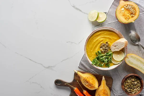 Vista superior de la sopa de calabaza molida otoñal en la superficie de mármol - foto de stock
