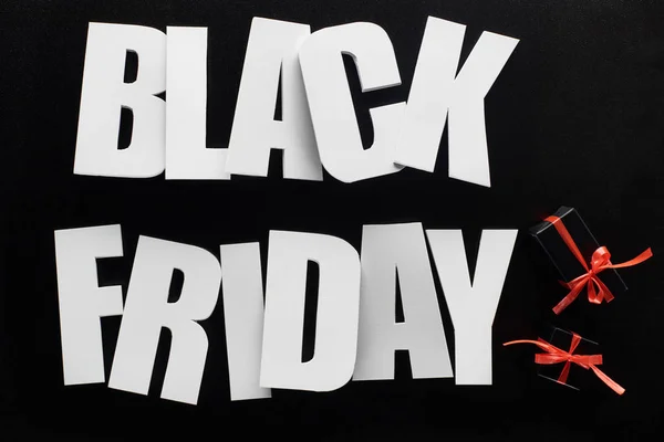 Ansicht von Black Friday Schriftzug und Präsente isoliert auf Schwarz — Stockfoto