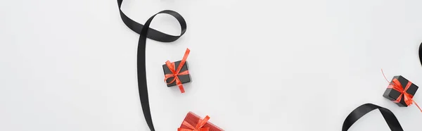 Top view of black ribbon and red gift boxes on white background, panoramic shot — Stock Photo