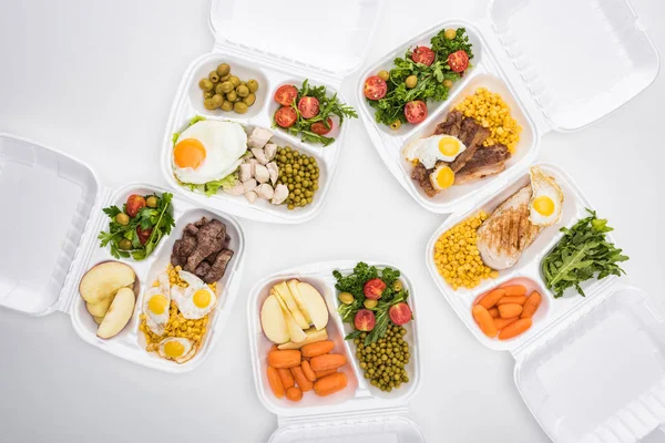 Ansicht der Ökopakete mit Äpfeln, Gemüse, Fleisch, Spiegeleiern und Salaten auf weißem Hintergrund — Stockfoto