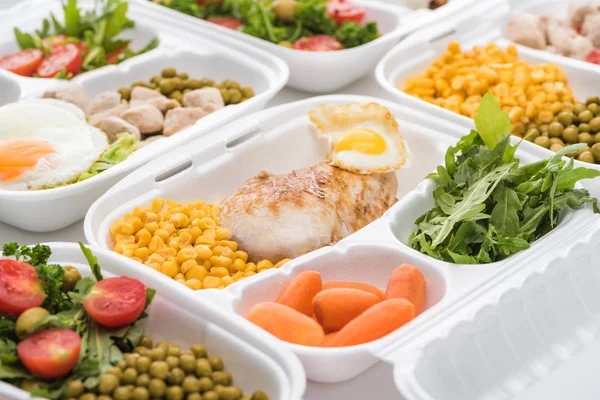 Enfoque selectivo del paquete ecológico con rúcula, verduras y carne sobre fondo blanco - foto de stock