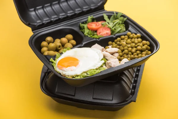 Pacote ecológico com legumes, carne, ovo frito e salada isolada em amarelo — Fotografia de Stock