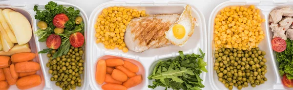 Tiro panorâmico de pacotes ecológicos com maçãs, legumes, carne, ovos fritos e saladas em fundo branco — Fotografia de Stock