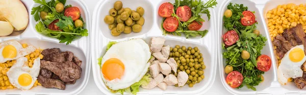 Plano panorámico de paquetes ecológicos con manzanas, verduras, carne, huevos fritos y ensaladas sobre fondo blanco — Stock Photo