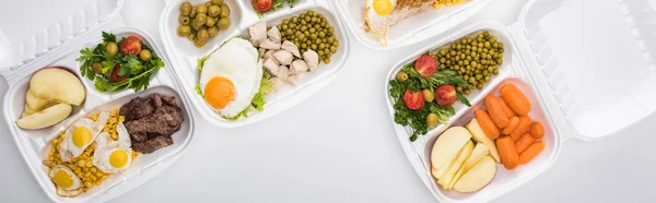 Plano panorámico de paquetes ecológicos con manzanas, verduras, carne, huevos fritos y ensaladas sobre fondo blanco — Stock Photo