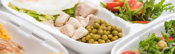 Plano panorámico de eco paquete con guisantes verdes, carne y ensalada sobre fondo blanco - foto de stock