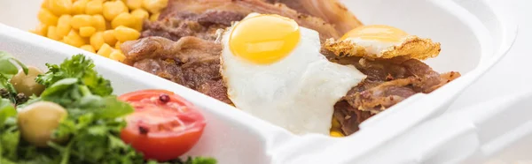 Plan panoramique de l'emballage écologique avec du maïs, de la viande, des œufs frits et de la salade sur fond blanc — Photo de stock