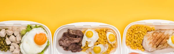 Plano panorámico de paquetes ecológicos con verduras, carne, huevos fritos aislados en amarillo - foto de stock