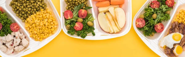 Plan panoramique des emballages écologiques avec légumes, pommes, viande, œufs frits et salades isolées sur jaune — Photo de stock