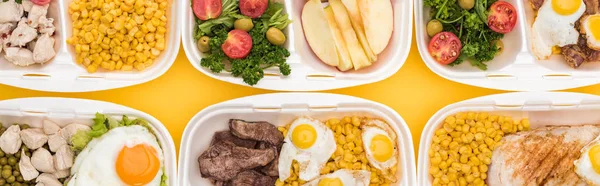 Tiro panorâmico de pacotes ecológicos com legumes, maçãs, carne, ovos fritos e saladas isoladas em amarelo — Fotografia de Stock