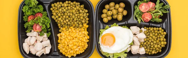 Panoramica delle confezioni ecologiche con verdure, carne, uova fritte e insalate isolate sul giallo — Foto stock