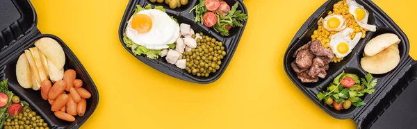 Plano panorámico de paquetes ecológicos con verduras, manzanas, carne, huevos fritos y ensaladas aisladas en amarillo - foto de stock