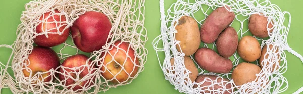 Vue de dessus des pommes et des pommes de terre dans des sacs à ficelle isolés sur vert — Photo de stock