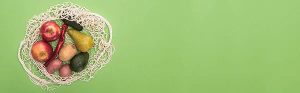 Top view of vegetables and fruits in string bag isolated on green — Stock Photo