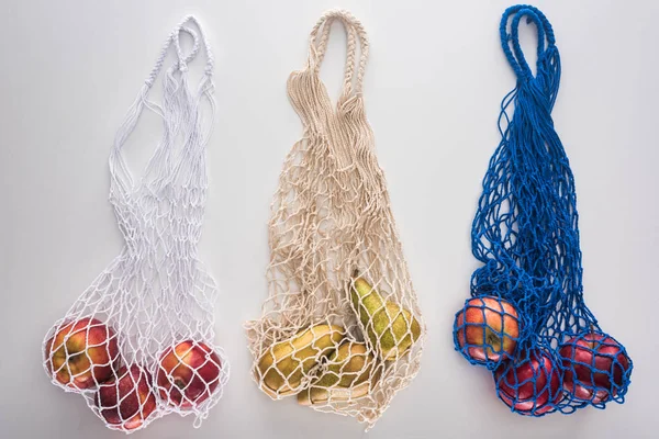 Vista dall'alto della frutta in sacchetti di corda eco friendly isolati su bianco — Foto stock