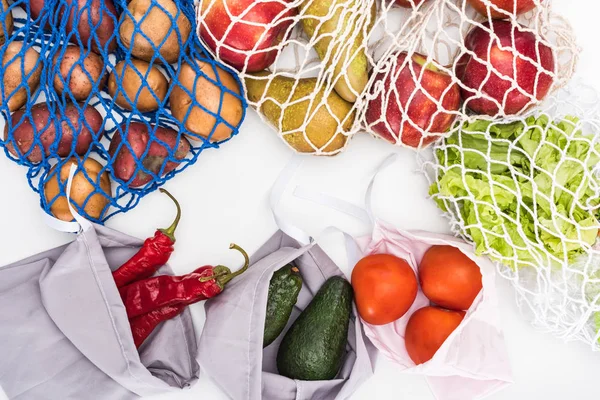 Vista dall'alto di frutta e verdura fresca in sacchetti ecologici isolati su bianco — Foto stock