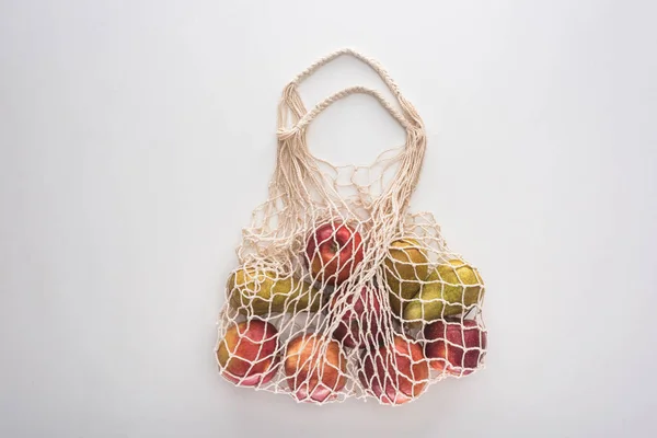 Vista superior de manzanas y peras en bolsa de cuerda ecológica aislada en blanco - foto de stock
