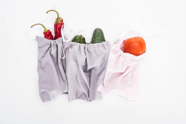 Vue de dessus des avocats frais, tomates et piments dans des sacs écologiques isolés sur blanc — Photo de stock