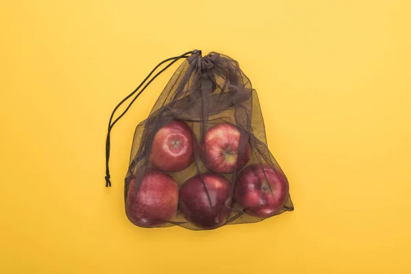 Vue de dessus des pommes mûres dans un sac écologique isolé sur jaune — Photo de stock