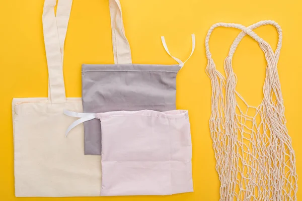 Top view of empty eco friendly bags isolated on yellow — Stock Photo