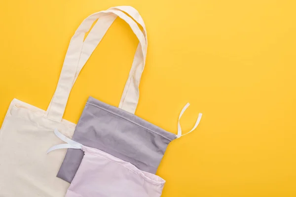 Top view of empty eco friendly bags isolated on yellow — Stock Photo