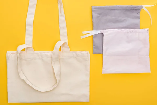 Top view of cotton eco friendly bags isolated on yellow — Stock Photo