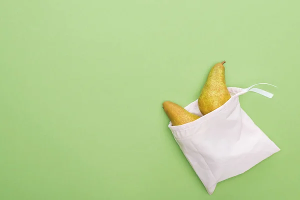 Top view of pears in eco friendly white bag isolated on green — Stock Photo