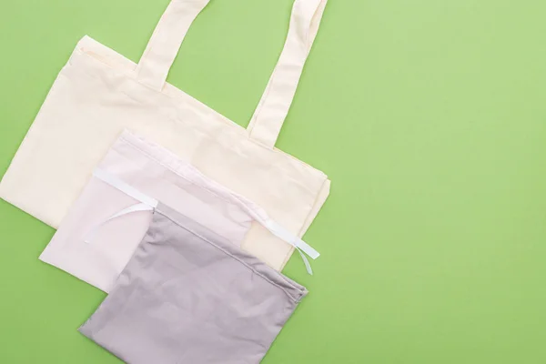 Top view of empty cotton eco bags isolated on green — Stock Photo