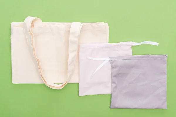 Top view of empty cotton eco bags isolated on green — Stock Photo