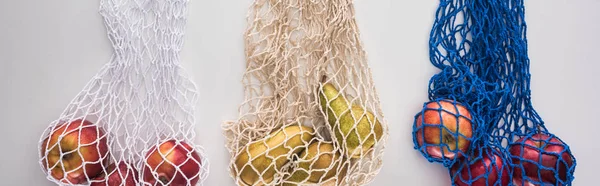 Vista superior de frutas em sacos de corda eco friendly isolados em branco, tiro panorâmico — Fotografia de Stock