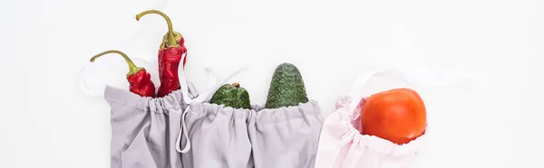 Top view of fresh avocados, tomatoes and chili peppers in eco friendly bags isolated on white, panoramic shot — Stock Photo