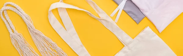 Top view of cotton eco friendly bags isolated on yellow, panoramic shot — Stock Photo