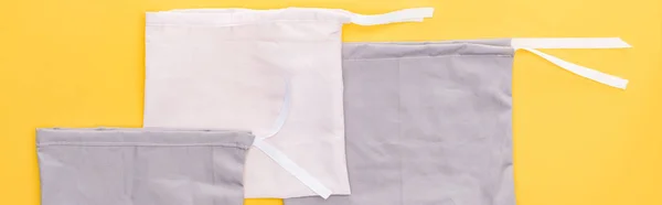 Top view of cotton eco friendly bags isolated on yellow, panoramic shot — Stock Photo