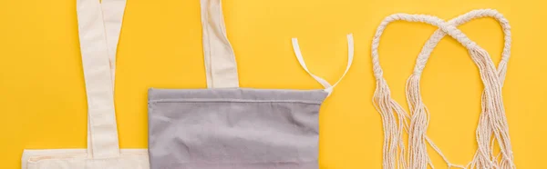 Top view of cotton eco friendly bags isolated on yellow, panoramic shot — Stock Photo