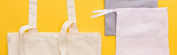 Vue de dessus des sacs écologiques en coton isolés sur jaune, panoramique — Photo de stock