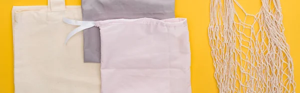 Top view of cotton eco friendly bags isolated on yellow, panoramic shot — Stock Photo