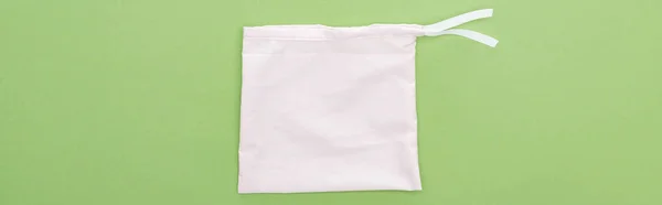 Вид сверху на экологически чистый белый мешок изолирован на зеленый, панорамный снимок — стоковое фото