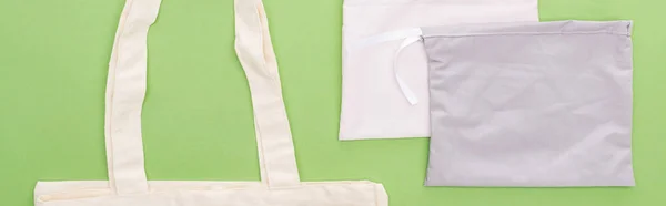 Top view of empty cotton eco bags isolated on green, panoramic shot — Stock Photo