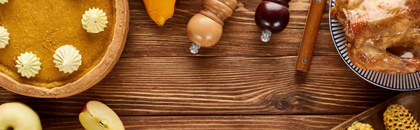 Vista superior del pavo asado, tarta de calabaza servida sobre mesa de madera, plano panorámico - foto de stock