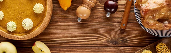 Top view of roasted turkey, pumpkin pie served on wooden table, panoramic shot — Stock Photo